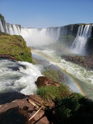 Iguasso Falls, Brazil. The water tumbles over cliffs, forming rainbows in the sunlight.  